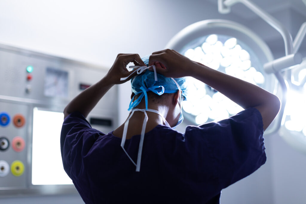 Surgeon wearing surgical mask doing into operation at Hospital