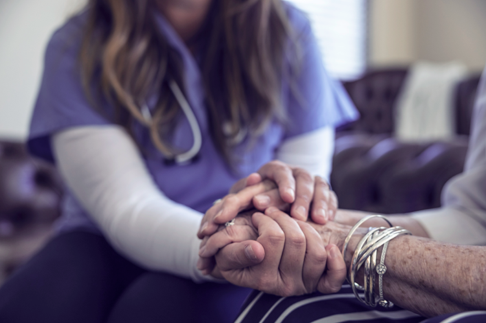 nurse practitioner holding patient's hand