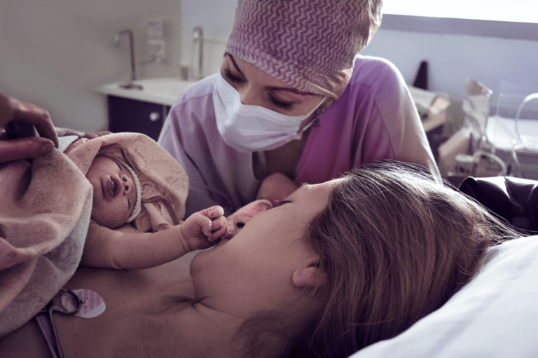 Midwife cares for mother and child after delivery.