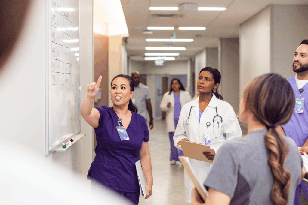 Hospital staff discussing the schedule on the whiteboard in the hallway