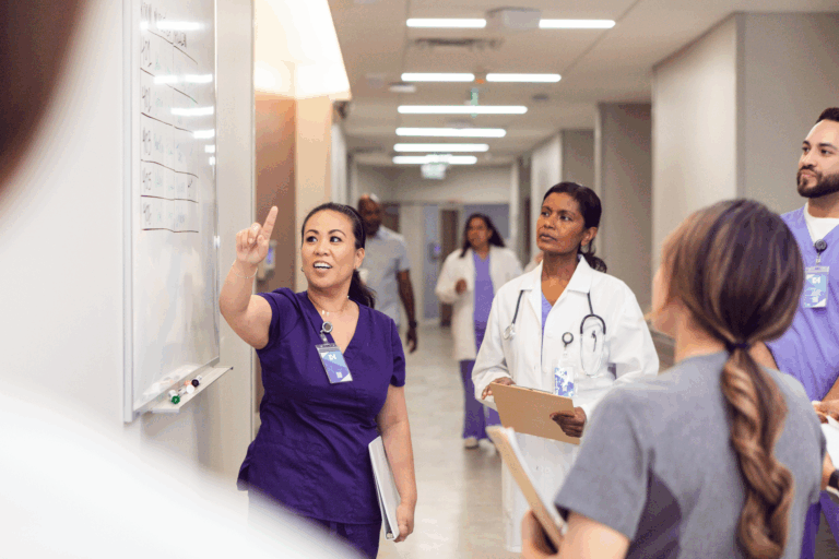 Hospital staff discussing the schedule on the whiteboard in the hallway
