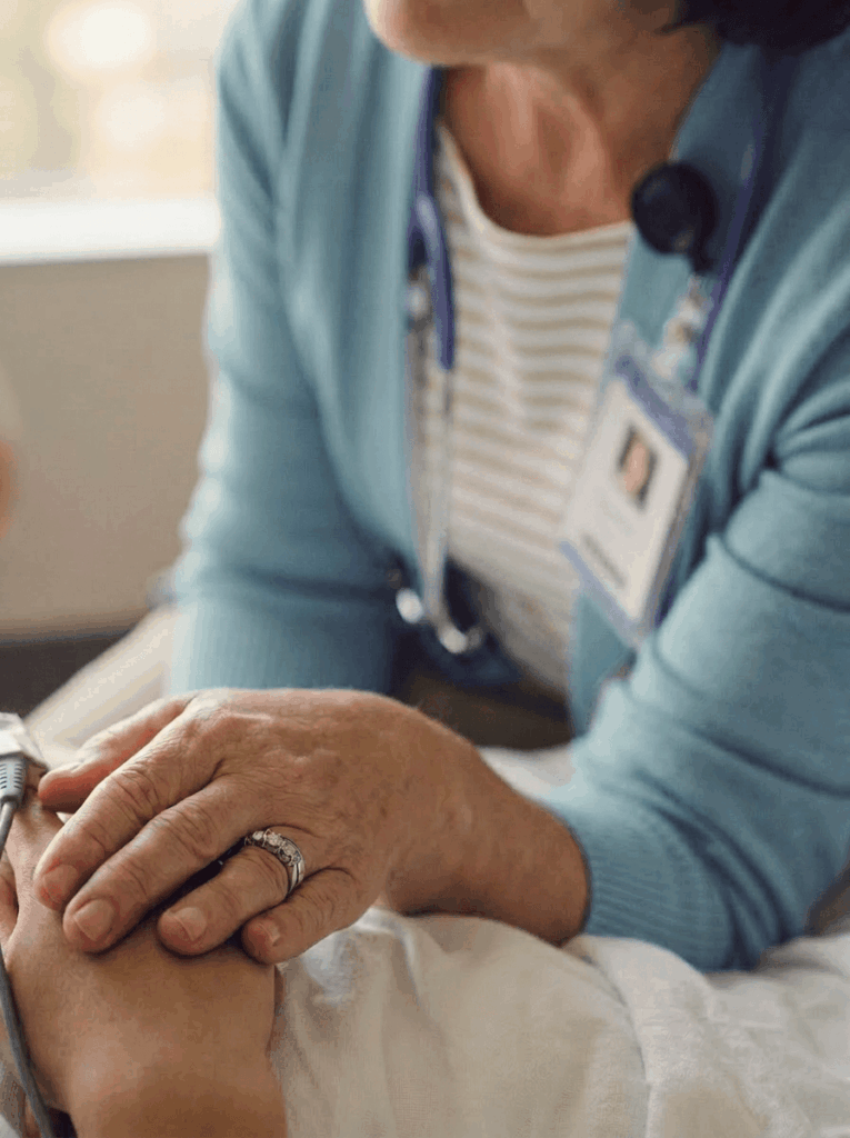 Female clinician holding patients hand