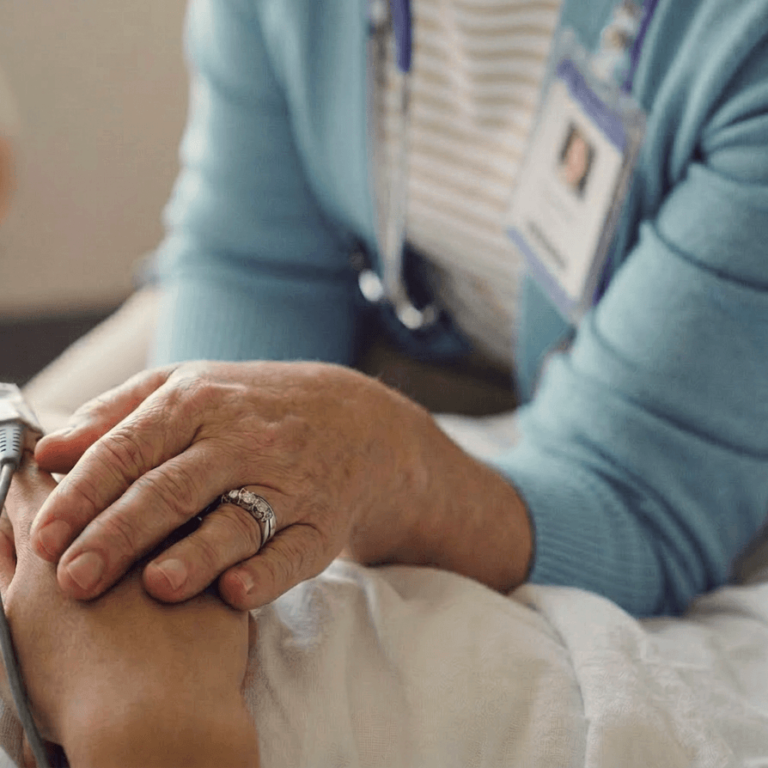 Female clinician holding patients hand