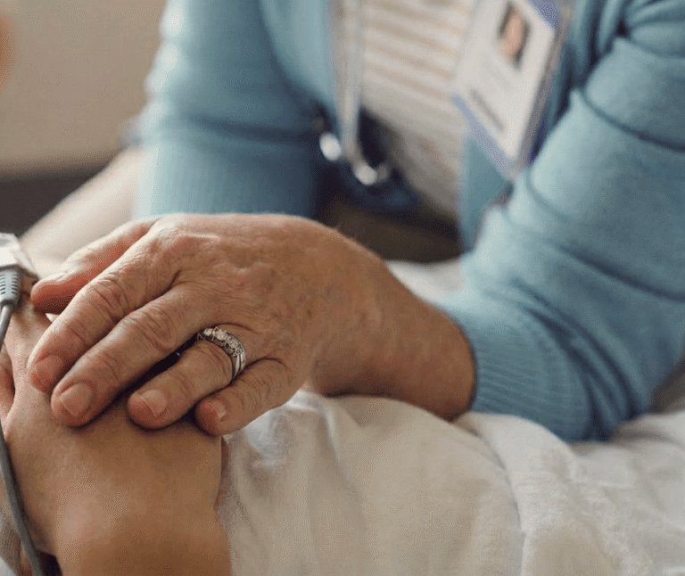 Female clinician holding patients hand